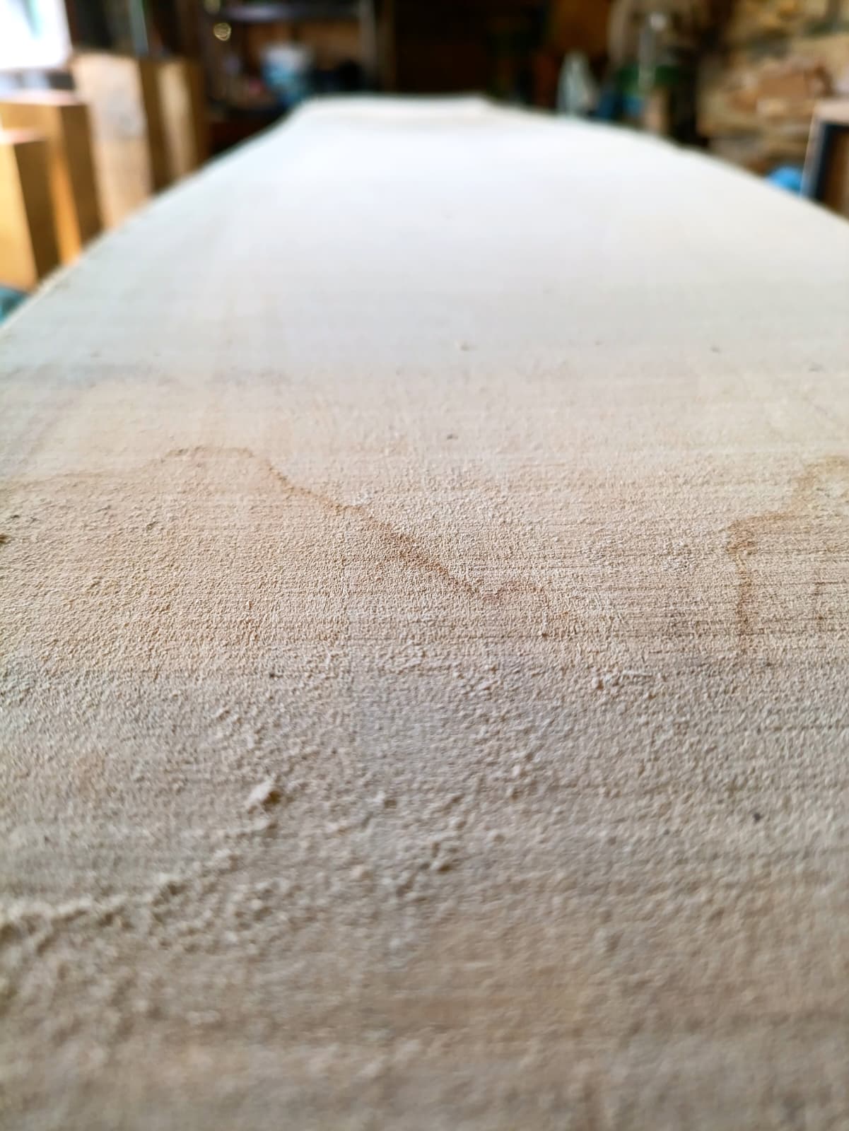 Une planche de bois brut en cours de sélection